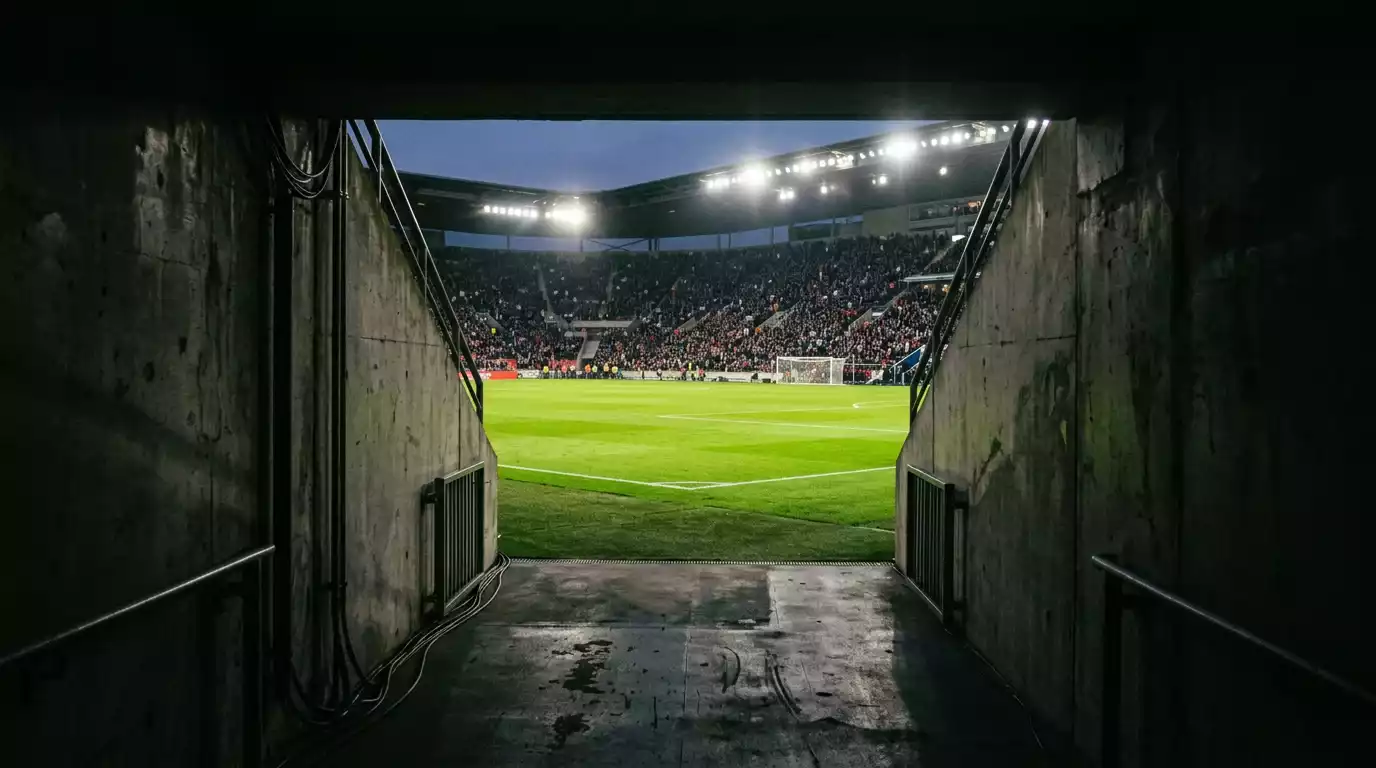 Túnel de salida de un estadio de fútbol con la luz del campo al fondo antes de un partido